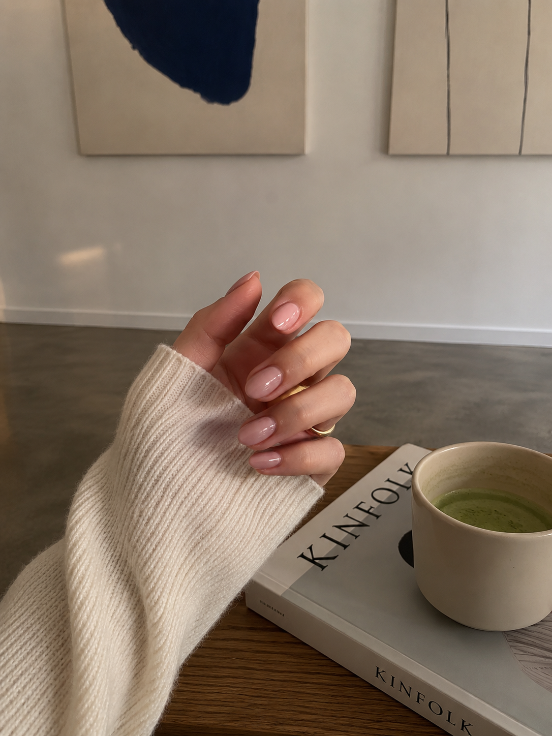 Minimal nude manicure with a cup on a table