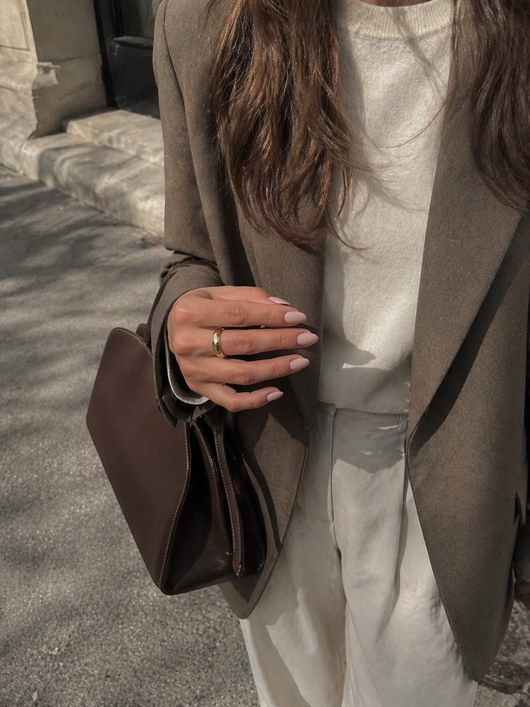 Deep red manicure on a marble salon counter with a Kinfolk book
